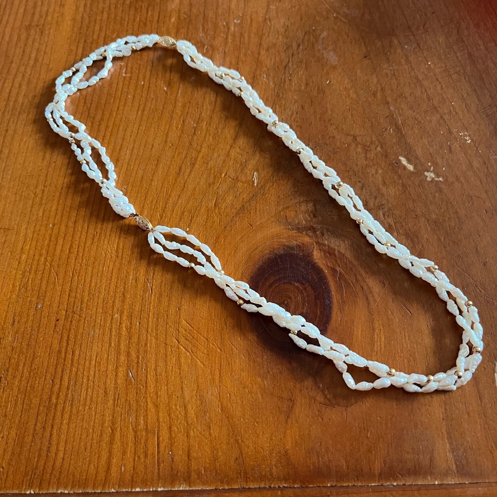 Three-strand Fresh water pearl necklace with 10k gold details. 23” length.